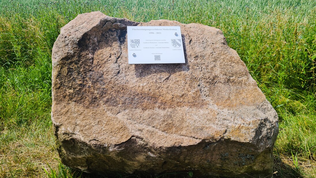 Stein mit befestigter Tafel mit Angaben zum Flurbereinigungsverfahren