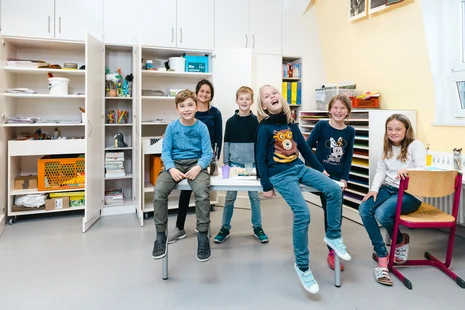 Kinder in einem Klassenzimmer freuen sich über die neue Ausstattung