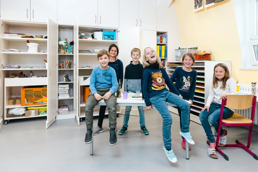 Kinder in einem Klassenzimmer freuen sich über die neue Ausstattung