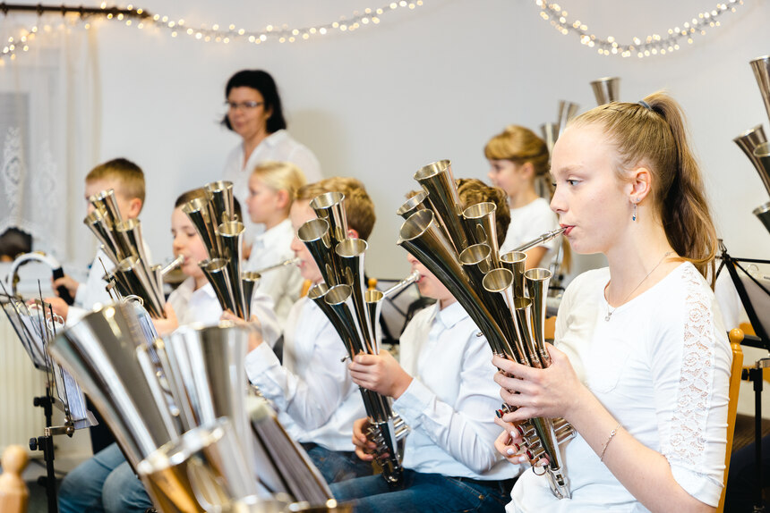 Mehrere Kinder sitzen nebeninander und spielen auf ihren Schlamaien