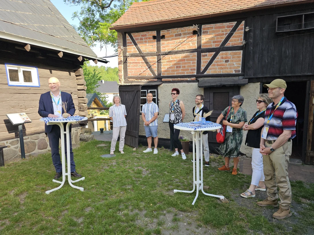 Jury steht vor einem Fachwerkhaus in legerer Runde