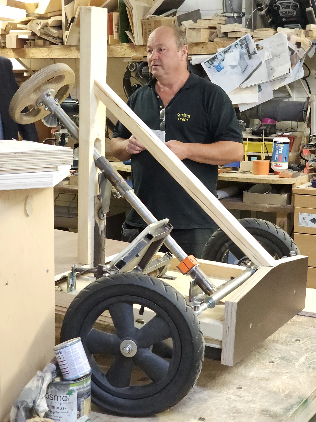 er steht in Mitten seiner Holzwerkstatt