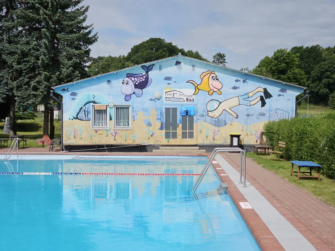 Blick über das Schwimmbecken zum Wirtschaftsgebäude