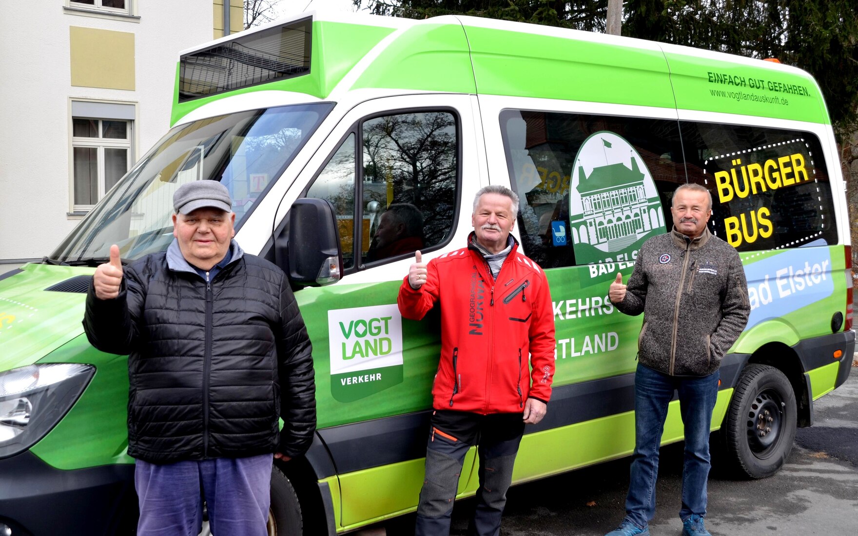 drei Männer winkend vor einem Kleinbus