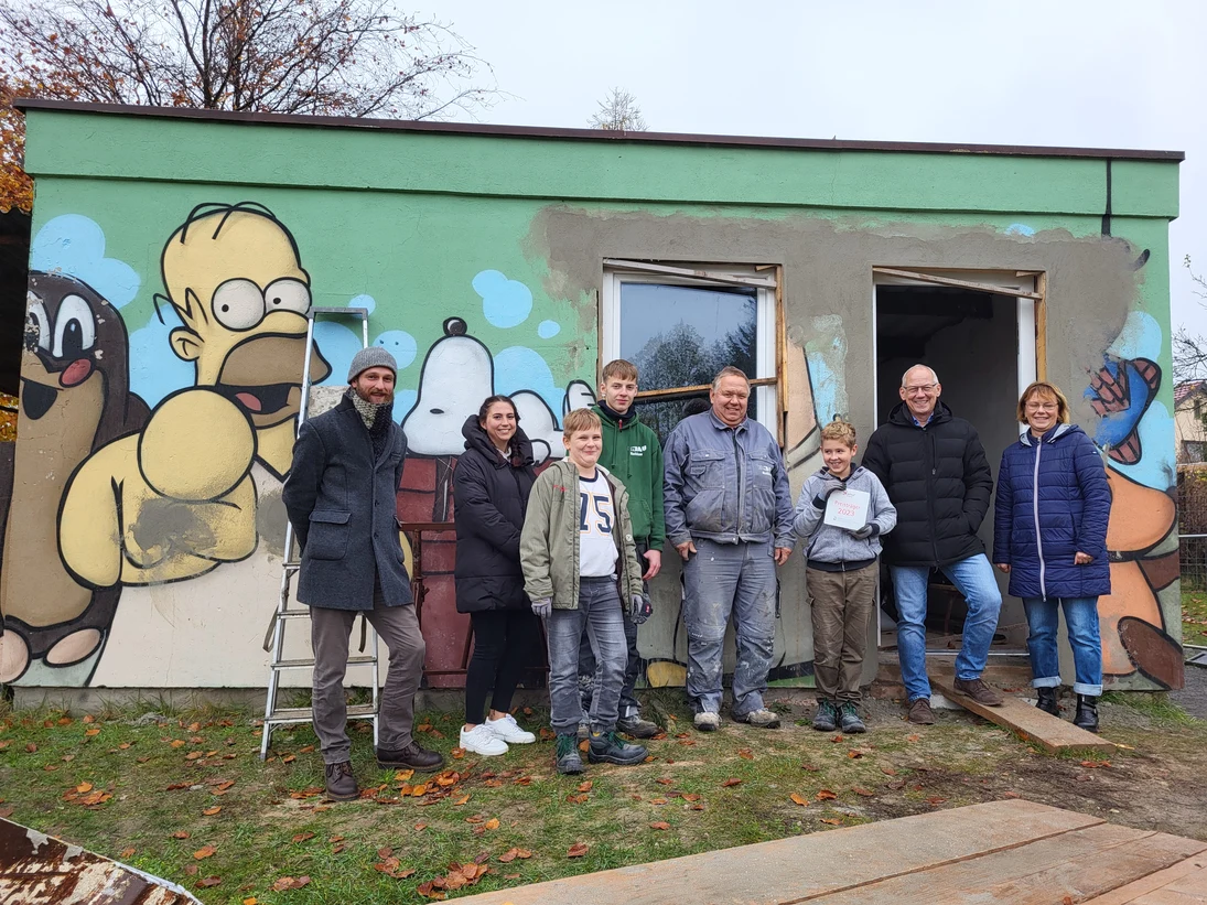 Die Jugendlichen präsentierten stolz ihren neuen Schulclub. Sie stehen vor der Hütte.