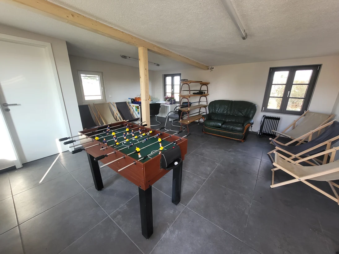 Blick in die Hütte. In der Mitte steht ein Tischkicker. An den Seiten sind verschiedene Sitzmöglichkeiten.