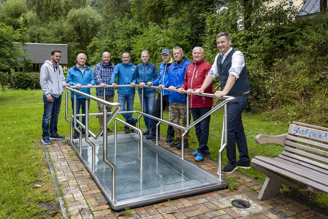eine Gruppe Männer steht vor dem neuen Kneippbecken