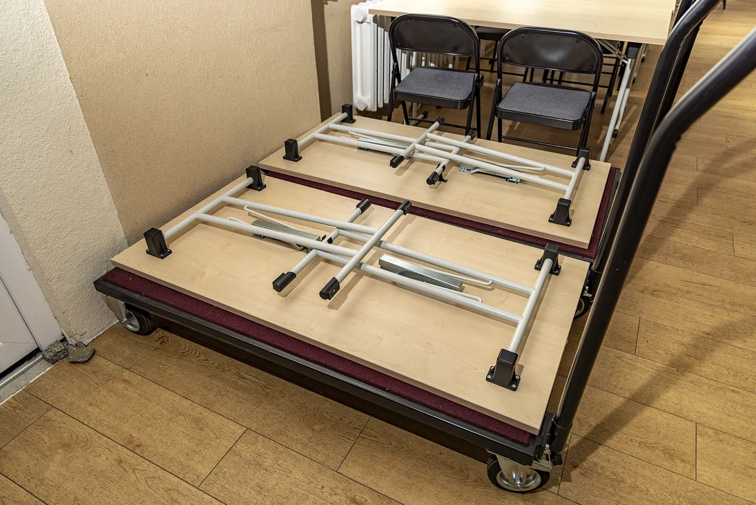 ein moderner zusammengeklappter Tisch liegt auf einer Transportkarre