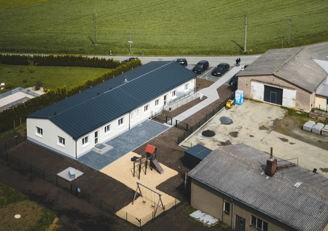 Luftbild mit Blick auf die neue Kita mit gestaltetem Außenbereich.