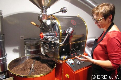 Frau röstet Kaffe mit einer Kaffeeröstmaschine. Foto: ERD e. V.