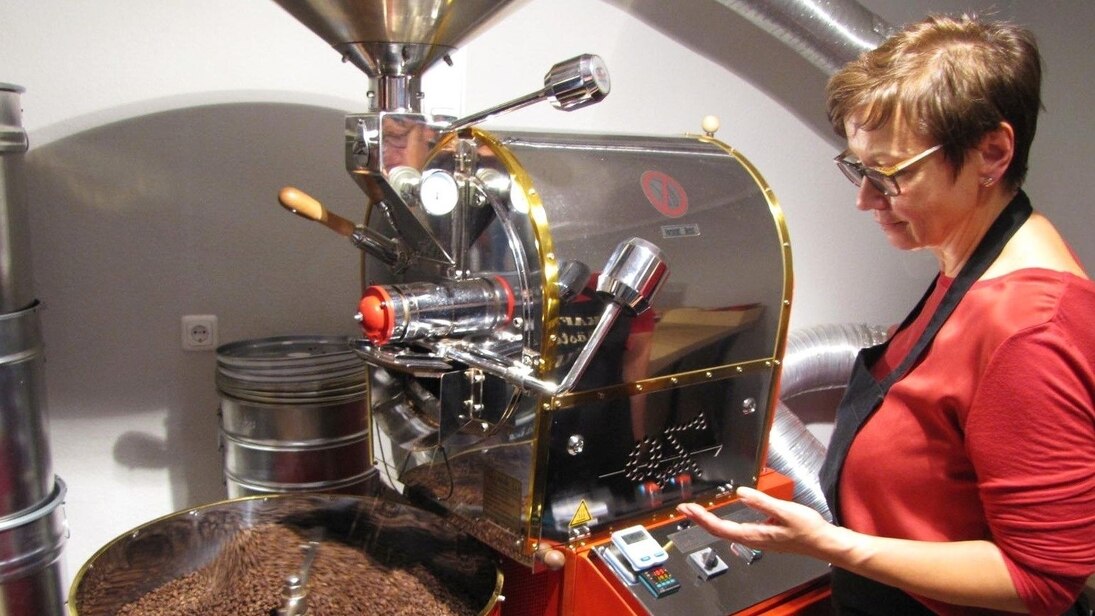 Die Inhaberin der Kaffeerösterei Müller steht vor ihrer neuen Kaffeeröstmaschine.