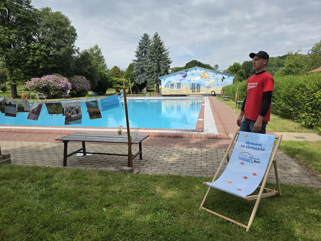 Blick auf Liegestuhl und Mitarbeiter vor dem Schwimmbecken
