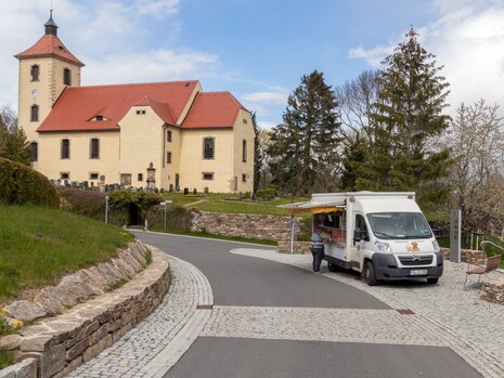 Auf der gepflasterten Ebene oberhalb der Treppe ein mobiler Händler, dahinter Kirche