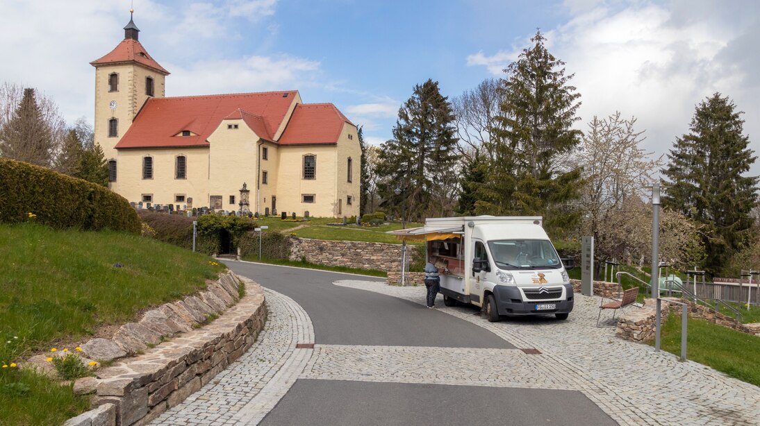 Auf der gepflasterten Ebene oberhalb der Treppe ein mobiler Händler, dahinter Kirche