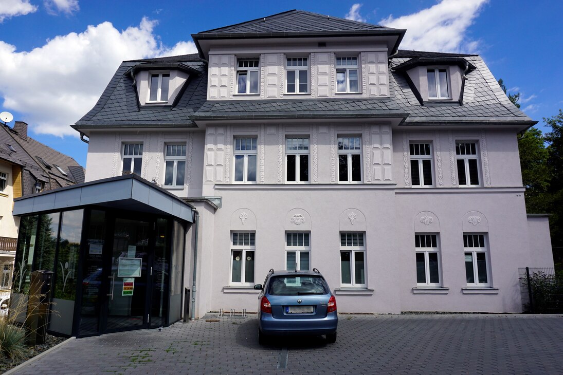 Frontalansicht des sanierten Gebäudes mit dem Praxiseingang auf der linken Seite.