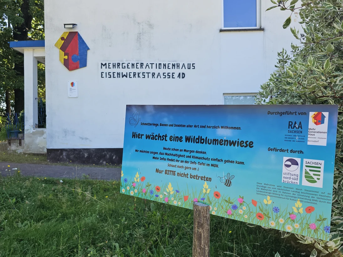 Schild "Hier wächst eine Wildblumenwiese" vor dem Mehrgenerationenhaus