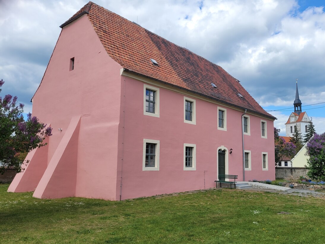 Die sanierte Heide-Pfarre erstrahlt in einem rötlichen Fassadenton