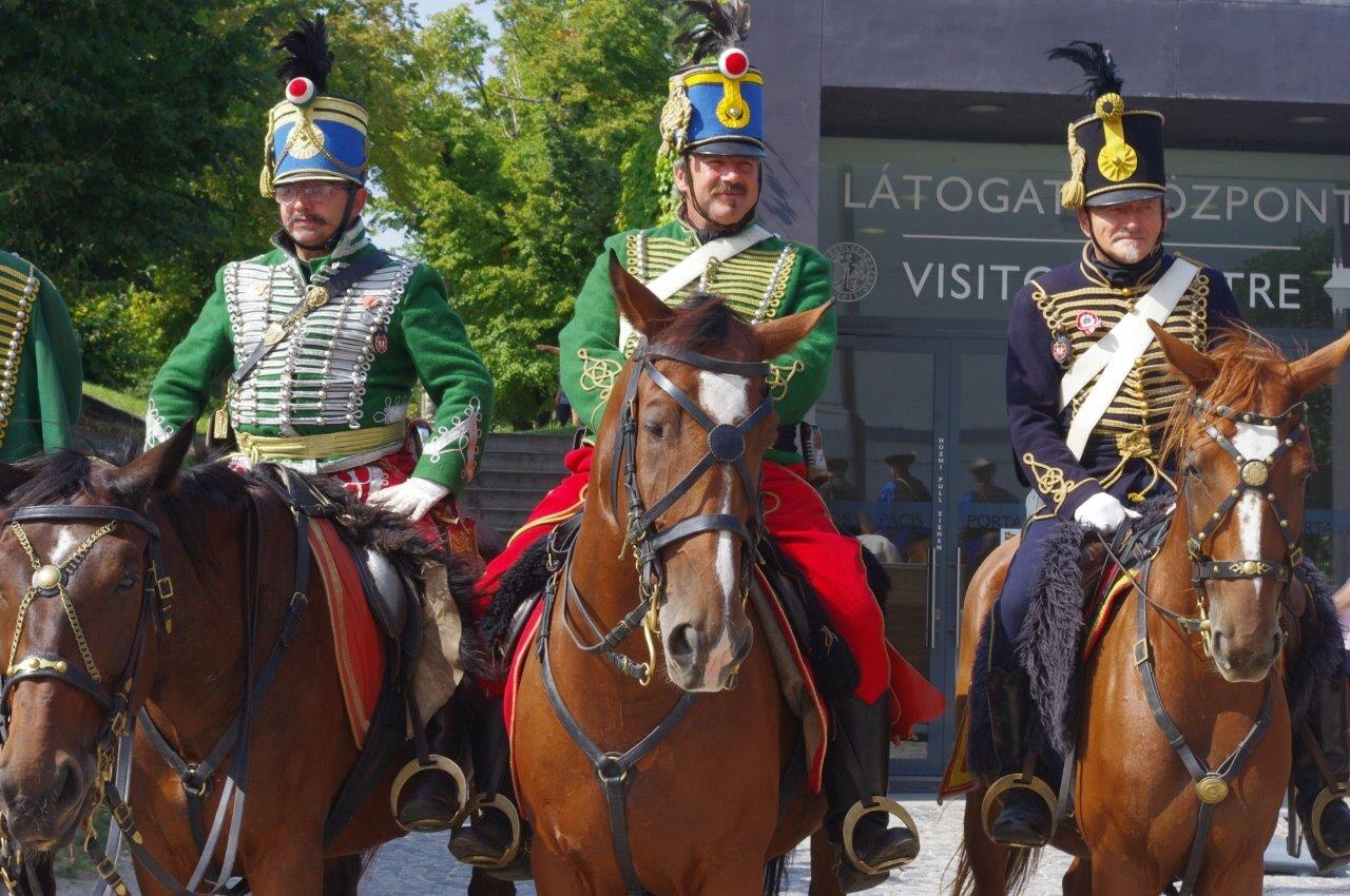 Drei Reiter in historischen Husarenuniformen bei einer Vorführung