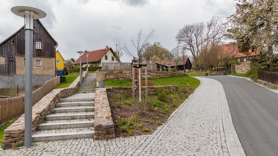 Blick auf den Hang, rechts Straße, die vom Fußweg durch hellere Granitpflasterung abgesetzt ist, links der Treppenaufgang