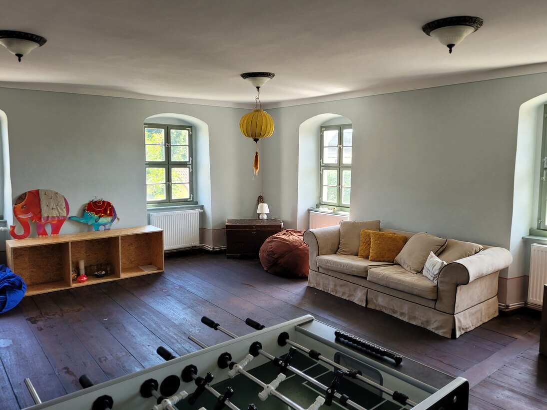Ein gemütlicher Raum mit einem Sofa, Tischkicker und Spielzeug
