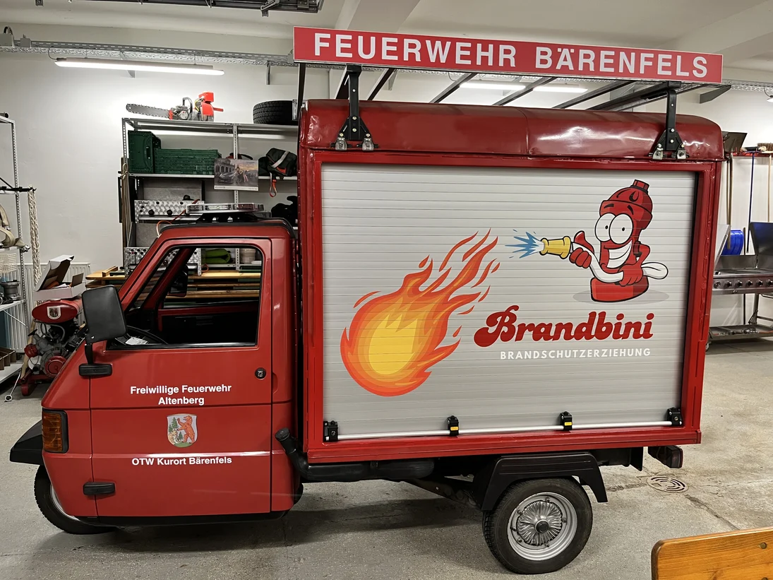rotes italienisches Dreirad-Nutzfahrzeug Piaggo APE als Feuerwehr-Einsatzfahrzeug mit der Aufschrift "Brandbini"