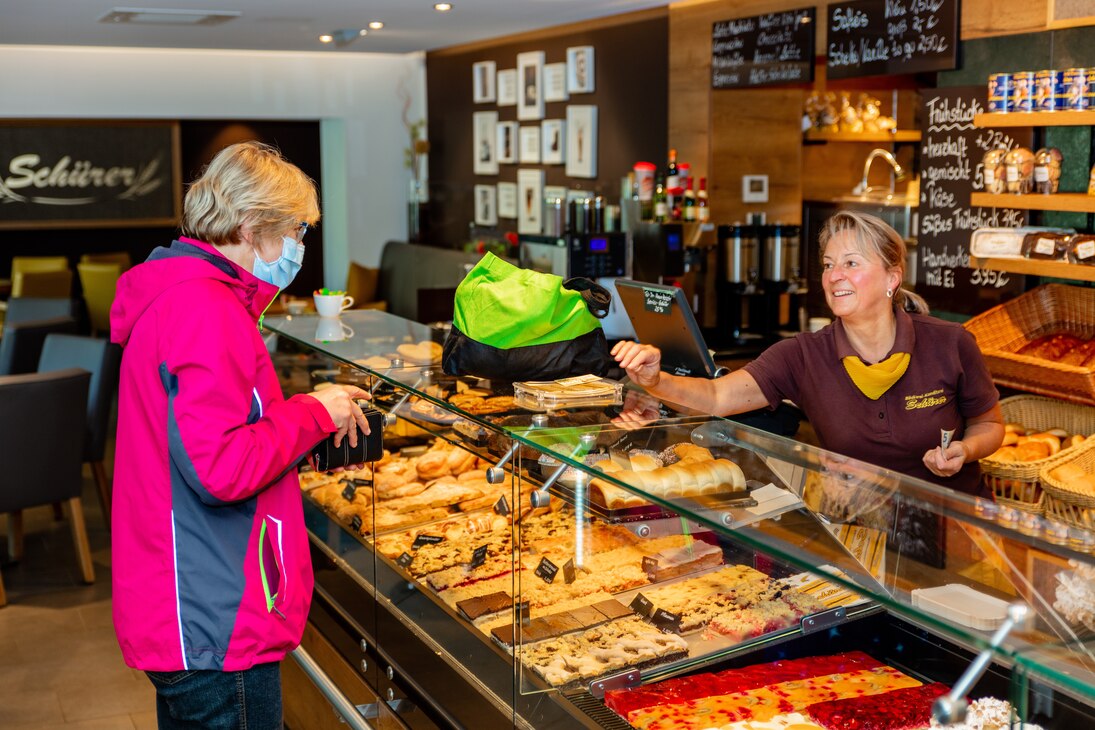 Eine Kundin kauft an der Ladentheke der Bäckerei ein.