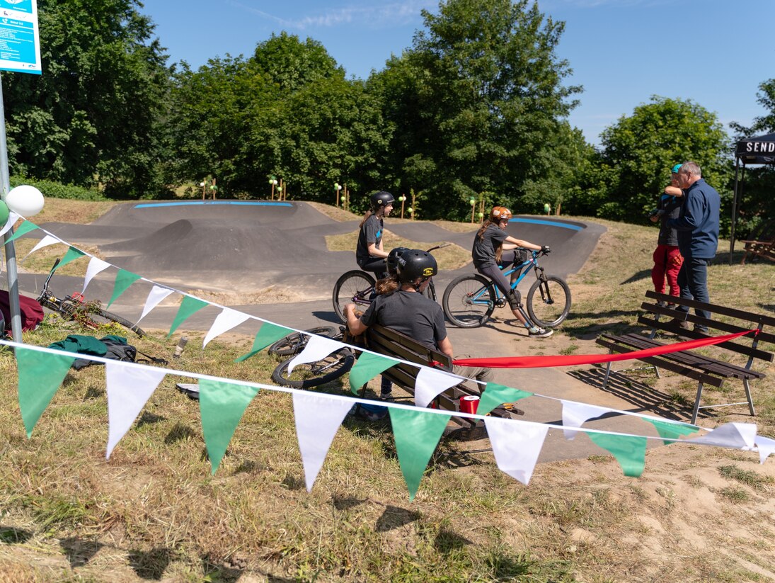 Mountainbiker stehen an dem neuen Parcours und erwarten die Streckenfreigabe