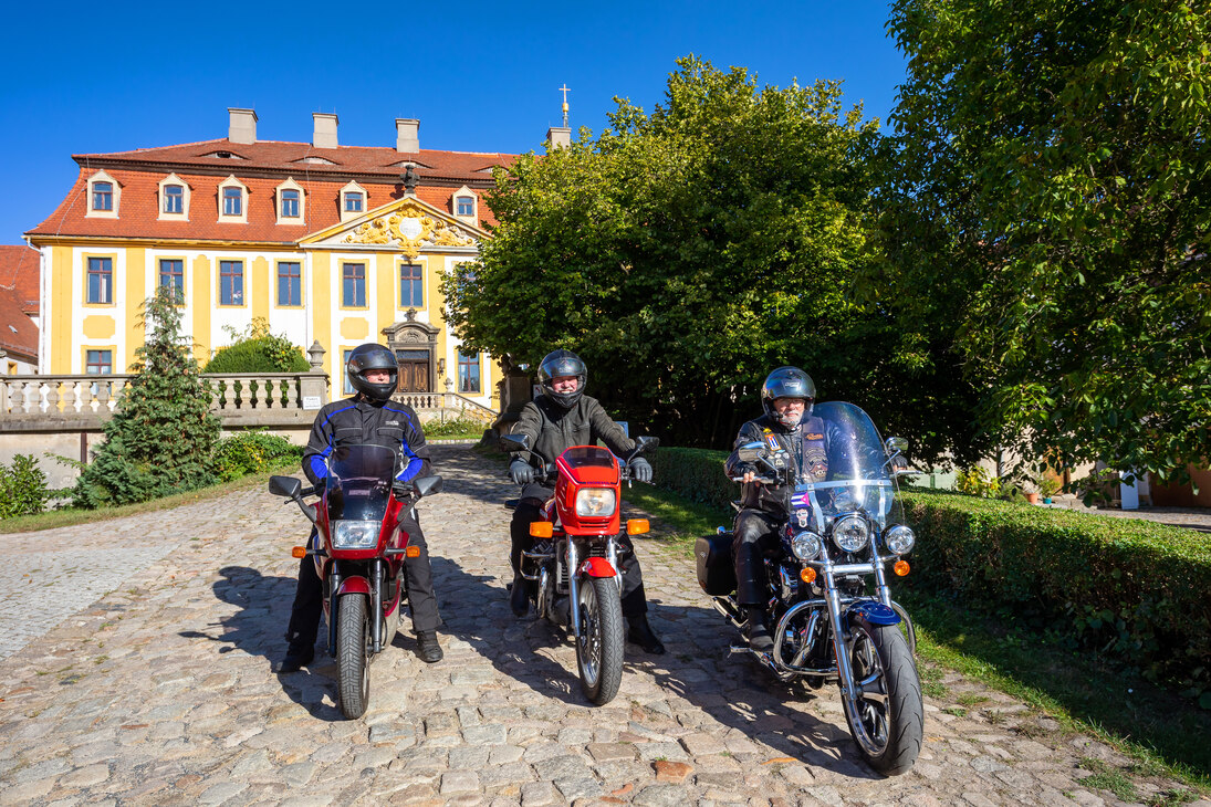 Drei Biker vor dem Barockschloss in Diesbar-Seußlitz, ein Halt auf der "Fürstlichen Route".