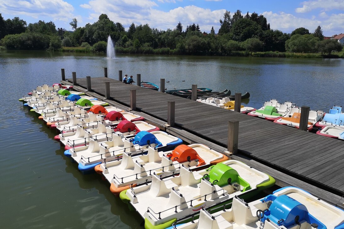 Holzsteg im Stausee Sohland mit rechts und links angebundenen Tretboten.