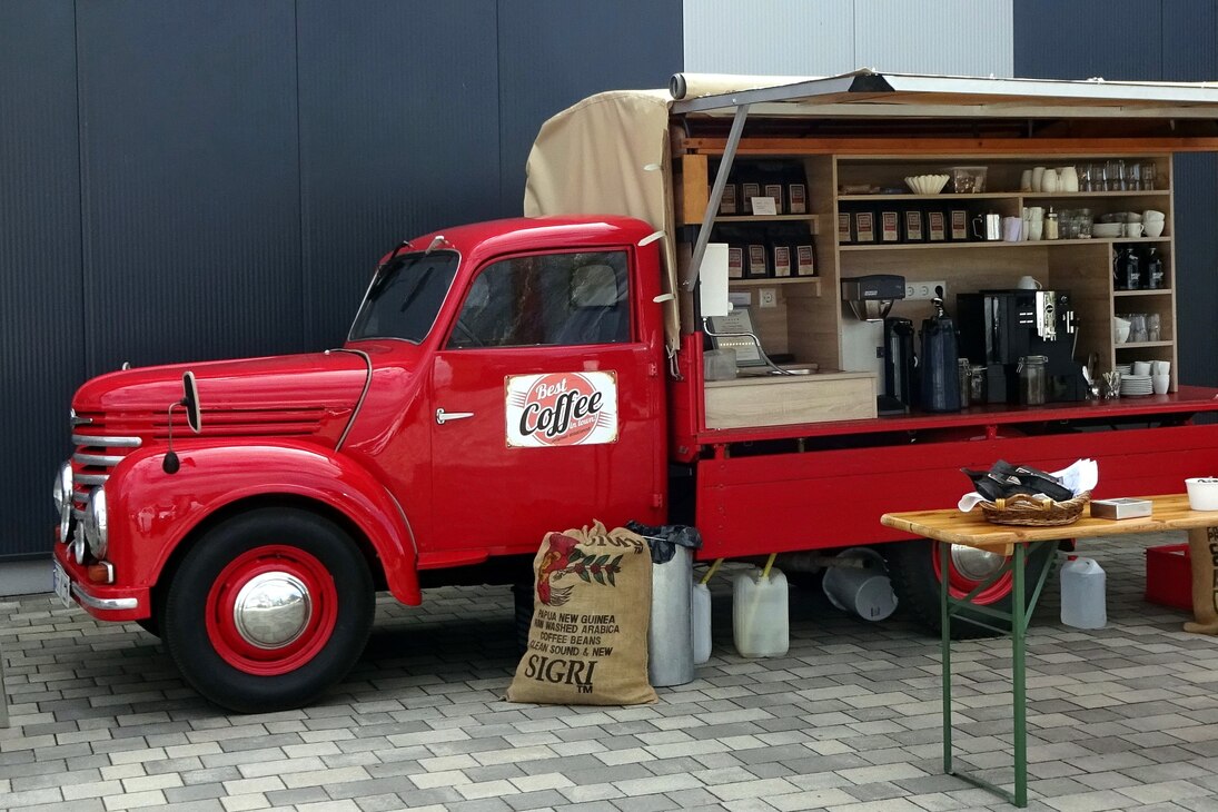Ein rotes Framomobil, welches zu einem fahrenden Kaffeestand umgebaut wurde.
