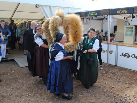 Siegerkrone wird von Landfrauen in Tracht aus dem Festzelt getragen