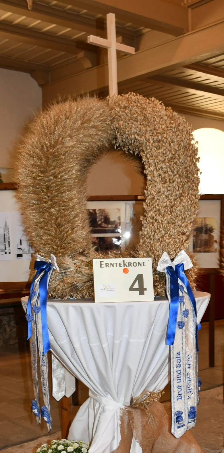 Erntekrone mit Kreuz und blauen Schleifen und Bändern