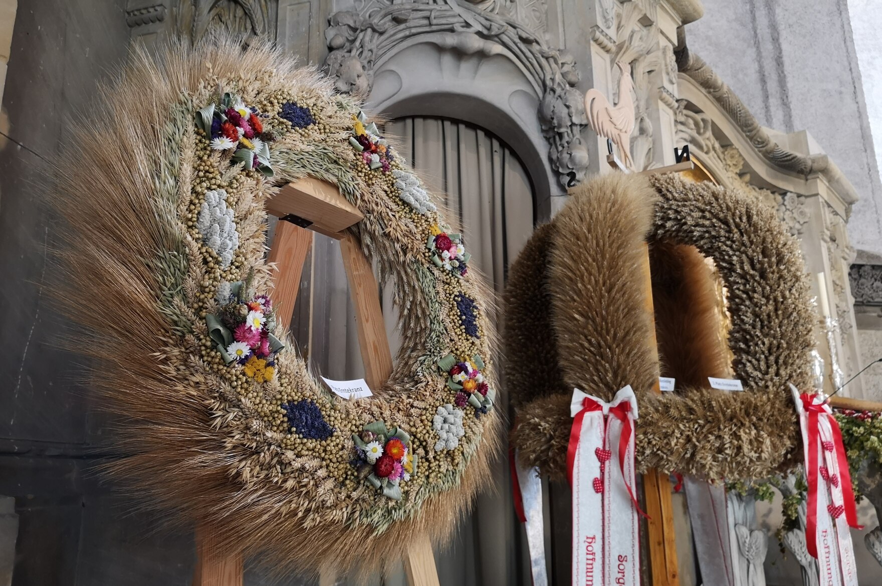 Erntekranz aus Getreide mit Blumenschmuck und Erntekrone mit rot bestickten Bändern