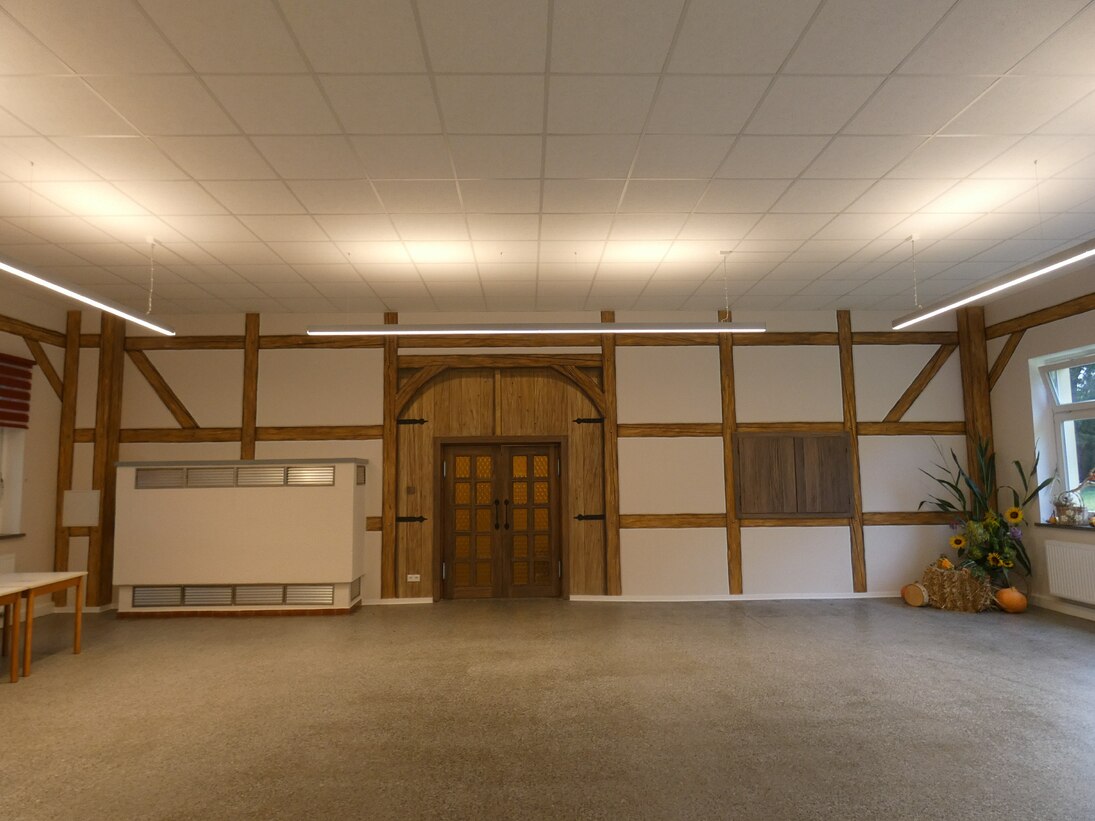 Saal mit Blick zum Eingangsbereich, Wandbemalung stellt Fachwerk dar sowie ein Tor um die Tür