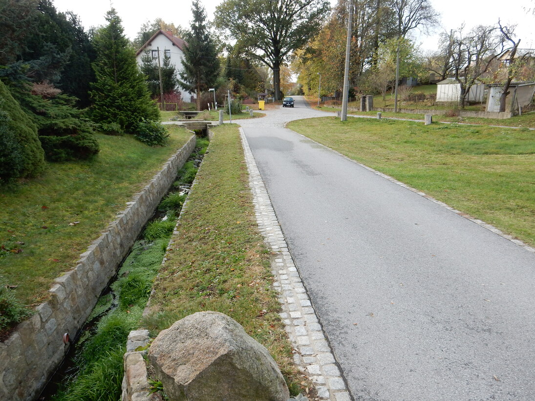 Kirchweg, südlicher Abschnitt, die neue Fahrbahn ist abgegrenzt mit Muldenrinnen und Pflasterstreifen, neue Ufermauer