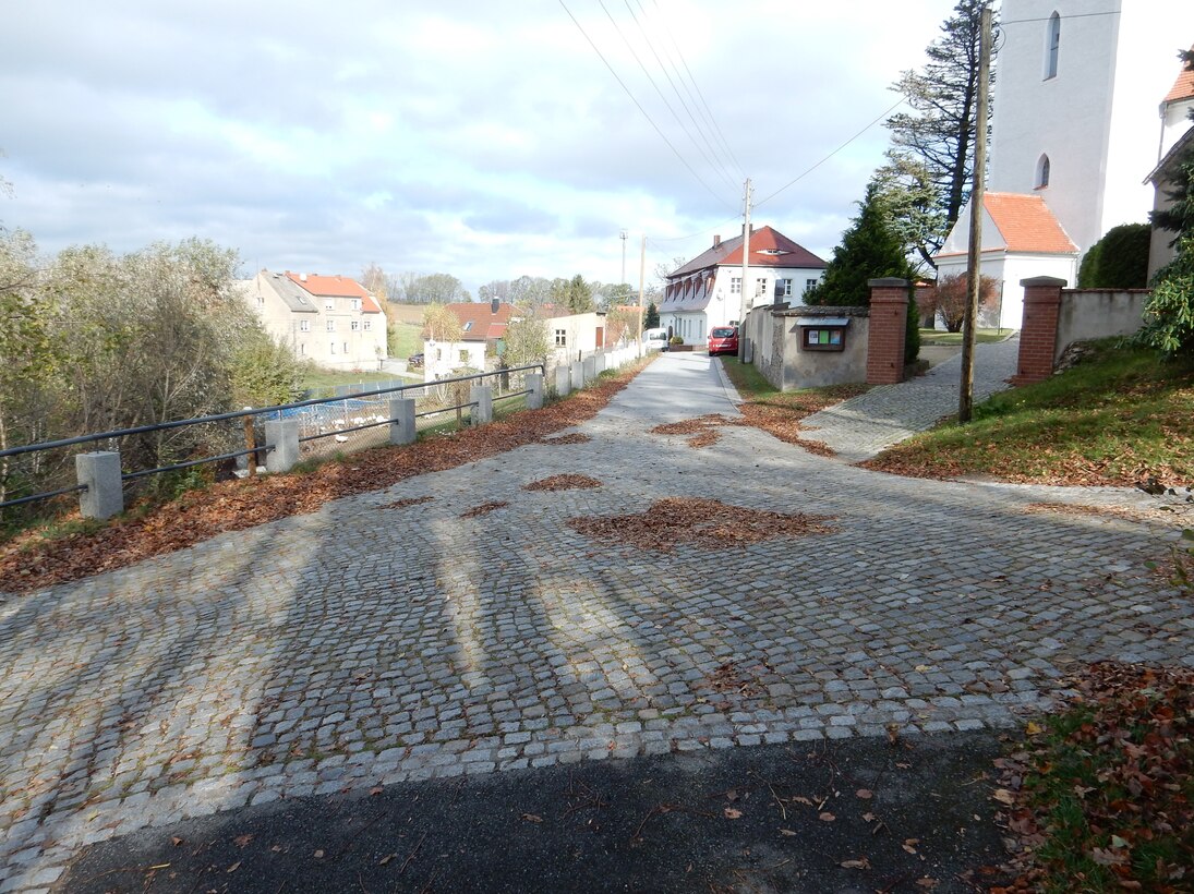 Kirchweg/Pfarrhausweg vor der Kirche nach der Baumaßnahme mit neuer Pflasterung und neuem Geländer