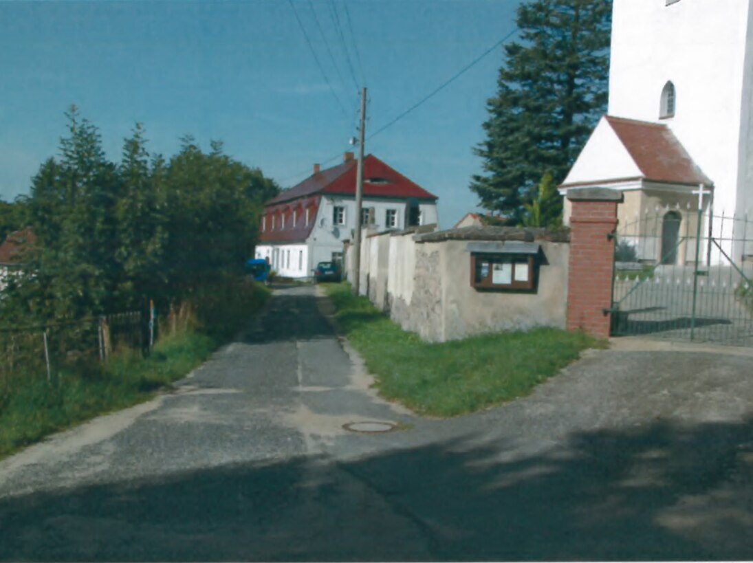 Kirchweg/Pfarrhausweg vor der Kirche vor der Baumaßnahme mit altem Straßenbelag