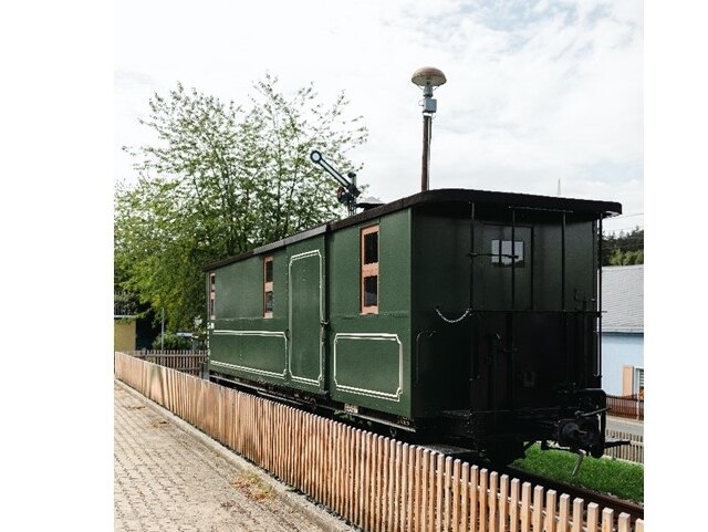 Ein dunkelgrüner Eisenbahnwaggon steht auf der eisenbahngeschichtlichen Schauanlage am ehemaligen Bahnhof Herold.