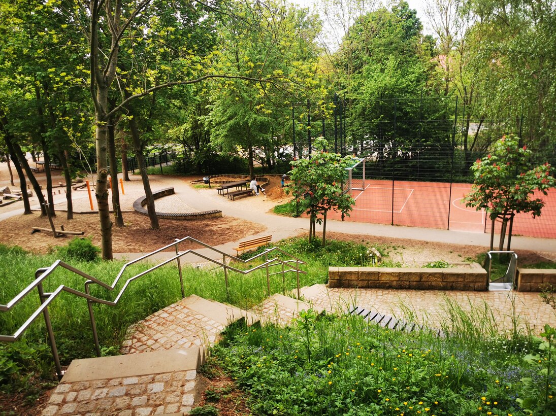 Blick von der Treppe auf Bolzplatz und Sandspielkasten