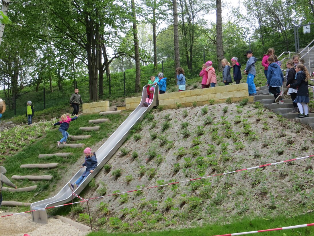 aktive Kinder auf Rutsche und Kletterbohlen 