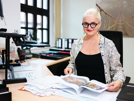 Eine Frau hält in einem Büro die Machbarkeitsstudie für den Skateplatz Mohsdorf in ihren Händen.