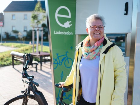 Die Bürgermeisterin von Radibor mit E-Bike vor der neuen Solarladesäule.