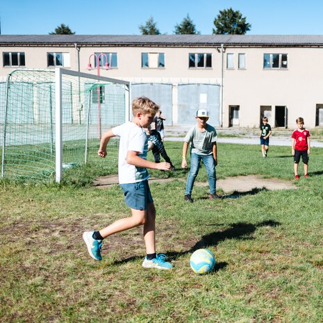 Kinder spielen auf einer Anlage in Putzkau Fußball.