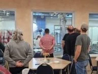 Mehrere Personen schauen durch ein großen Fenster in den Projktionsbereich