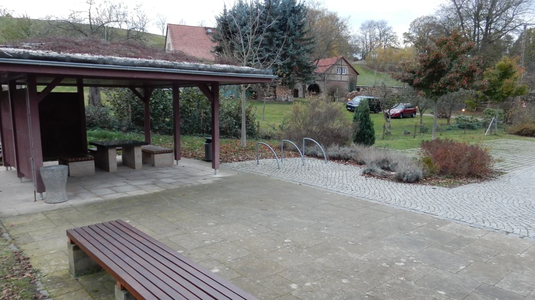 Rastplatz mit Unterstand, Sitzgelegenheiten und Fahrradbügeln, Belag aus Sandsteinplatten