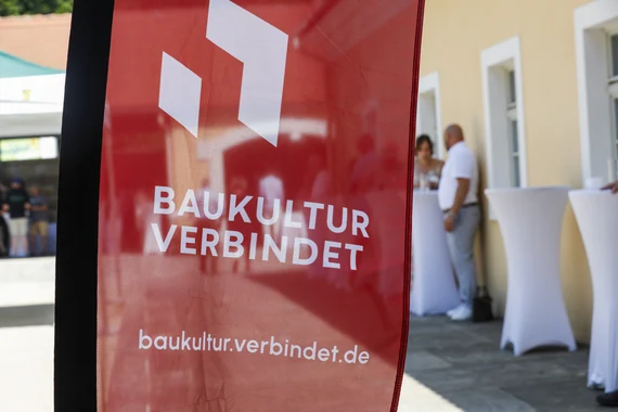 Logo Baukultur verbindet auf einer wehenden Fahne