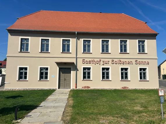 Vorderansicht des sanierten Hauses mit Schriftzug Gasthof Zur Goldene Sonne